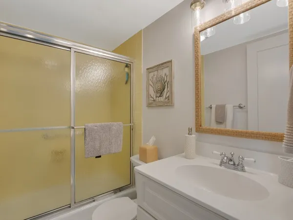 a bathroom with a sink mirror toilet and shower