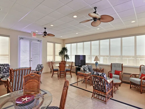a living room with furniture kitchen view and a large window