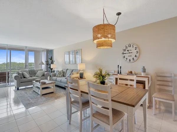 a living room with couches a dining table and chairs with a bookshelf