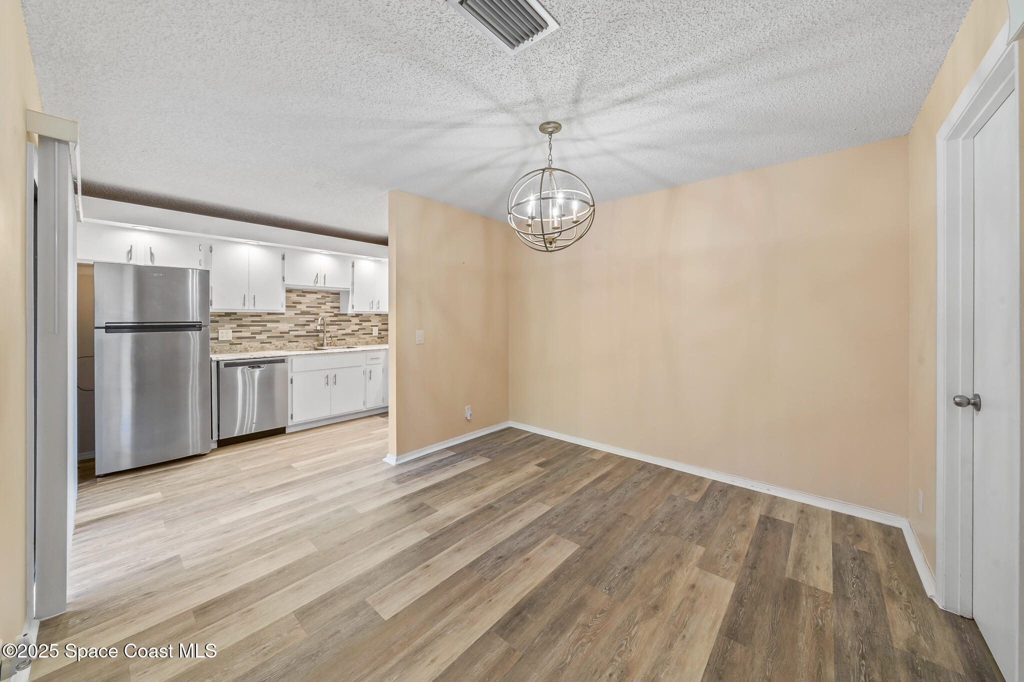 1713 Patty Circle Northeast Palm Bay, FL 32905 - Photo 11 of 26 a view of a kitchen with a dishwasher cabinets and wooden floor