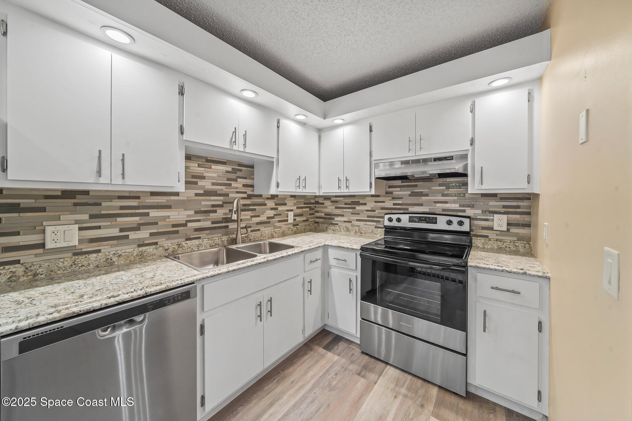 1713 Patty Circle Northeast Palm Bay, FL 32905 - Photo 14 of 26 a kitchen with stainless steel appliances granite countertop a sink a stove and cabinets