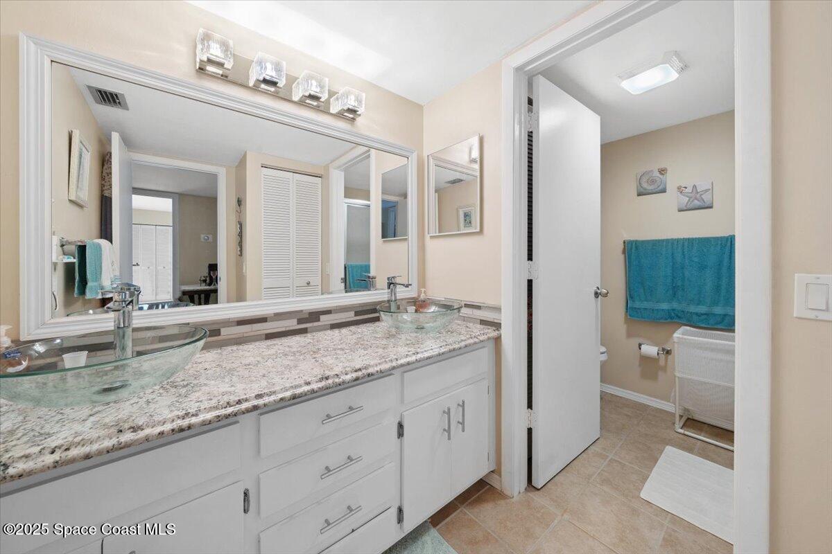 1713 Patty Circle Northeast Palm Bay, FL 32905 - Photo 20 of 26 a bathroom with a granite countertop sink mirror and toilet