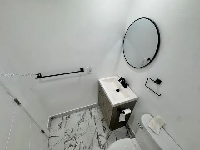 a backyard of a house with a table and chairs under an umbrella