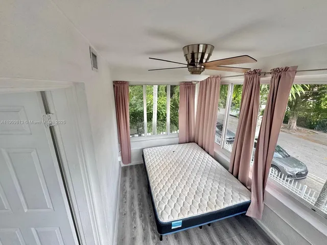 an empty room with windows entrance and wooden floor