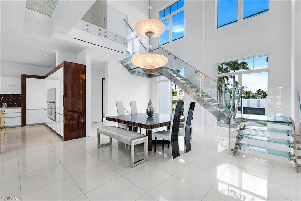 260 Channel Drive Naples, FL 34108 - Photo 14 of 48 a kitchen with stainless steel appliances kitchen island granite countertop a table chairs and a refrigerator