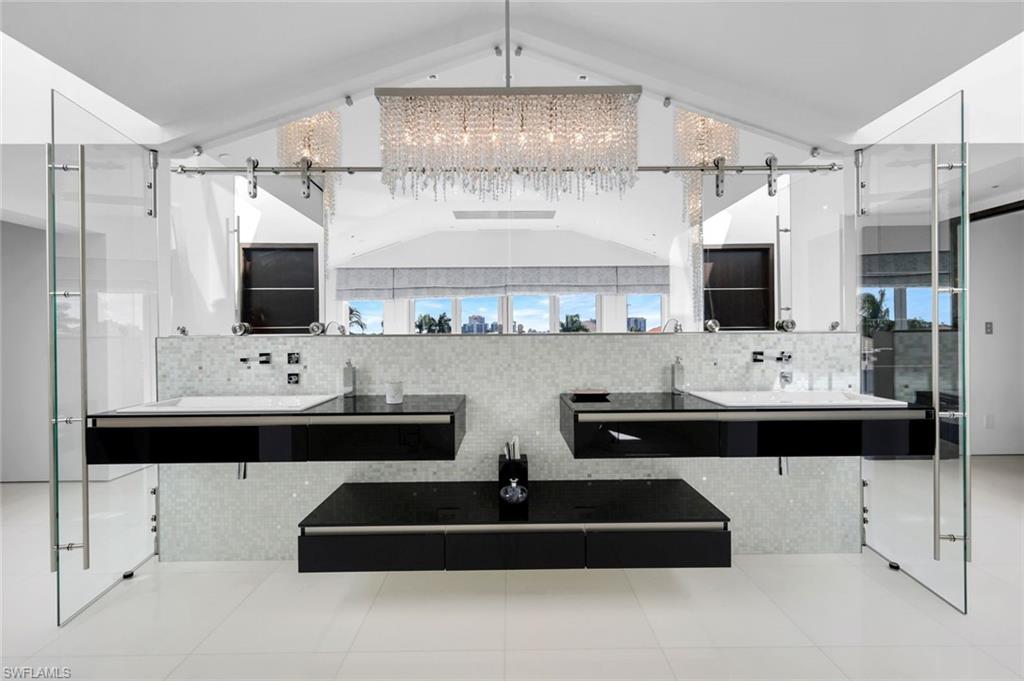 260 Channel Drive Naples, FL 34108 - Photo 19 of 48 a bathroom with double sink and a mirror