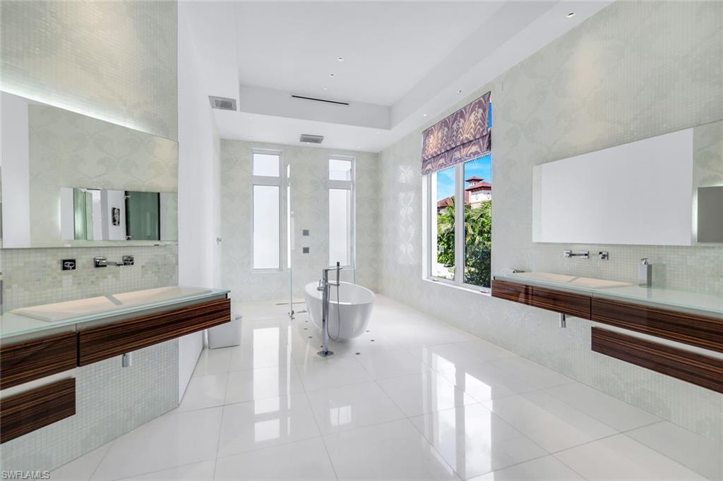 260 Channel Drive Naples, FL 34108 - Photo 25 of 48 a large spacious bathroom with a large tub sink and mirror