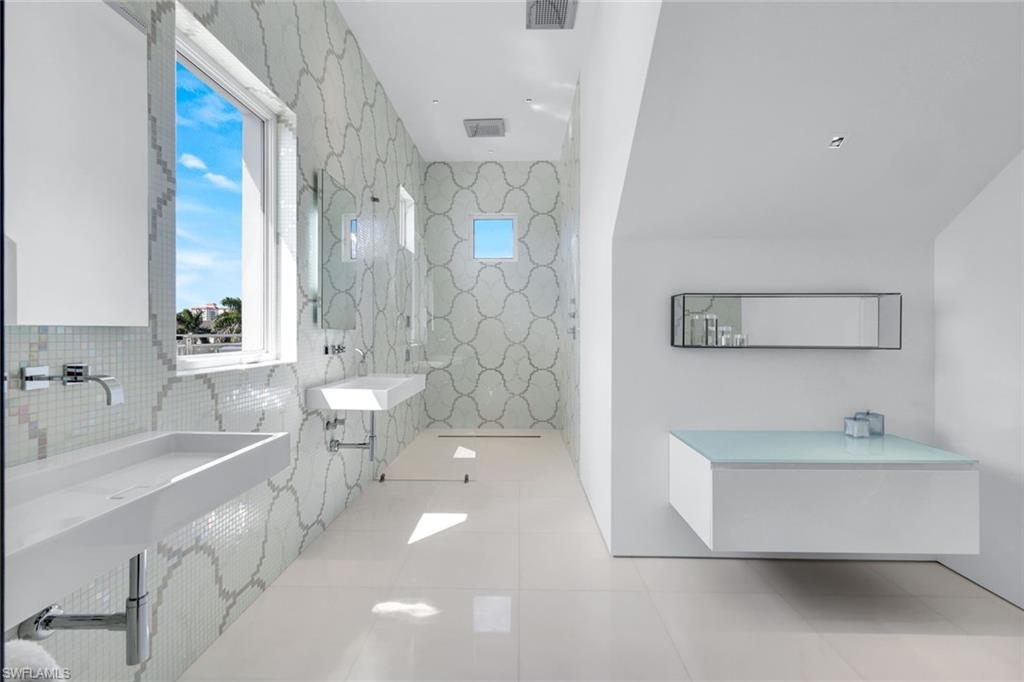 260 Channel Drive Naples, FL 34108 - Photo 29 of 48 a spacious bathroom with a double vanity sink a mirror and a bathtub