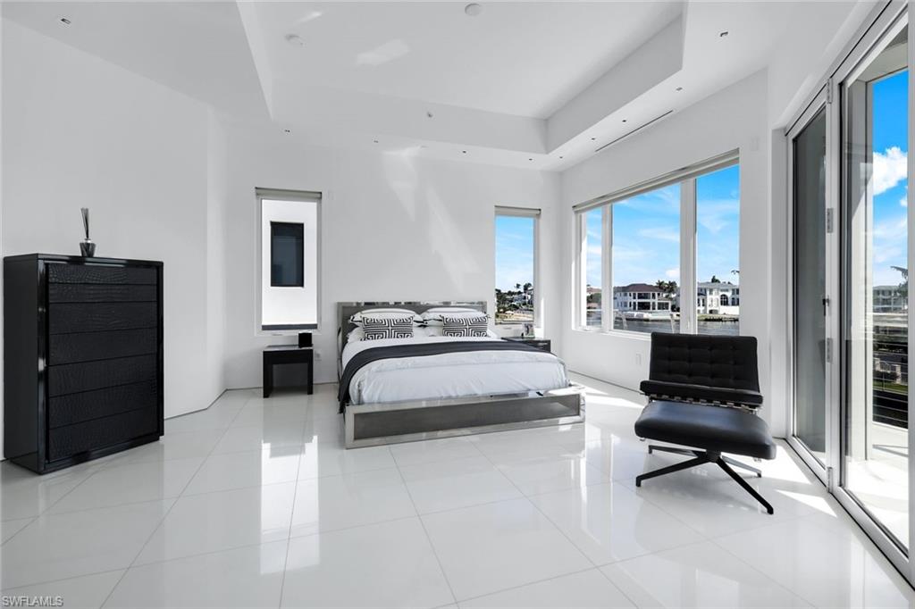 260 Channel Drive Naples, FL 34108 - Photo 30 of 48 a bedroom with a bed a chair and three windows