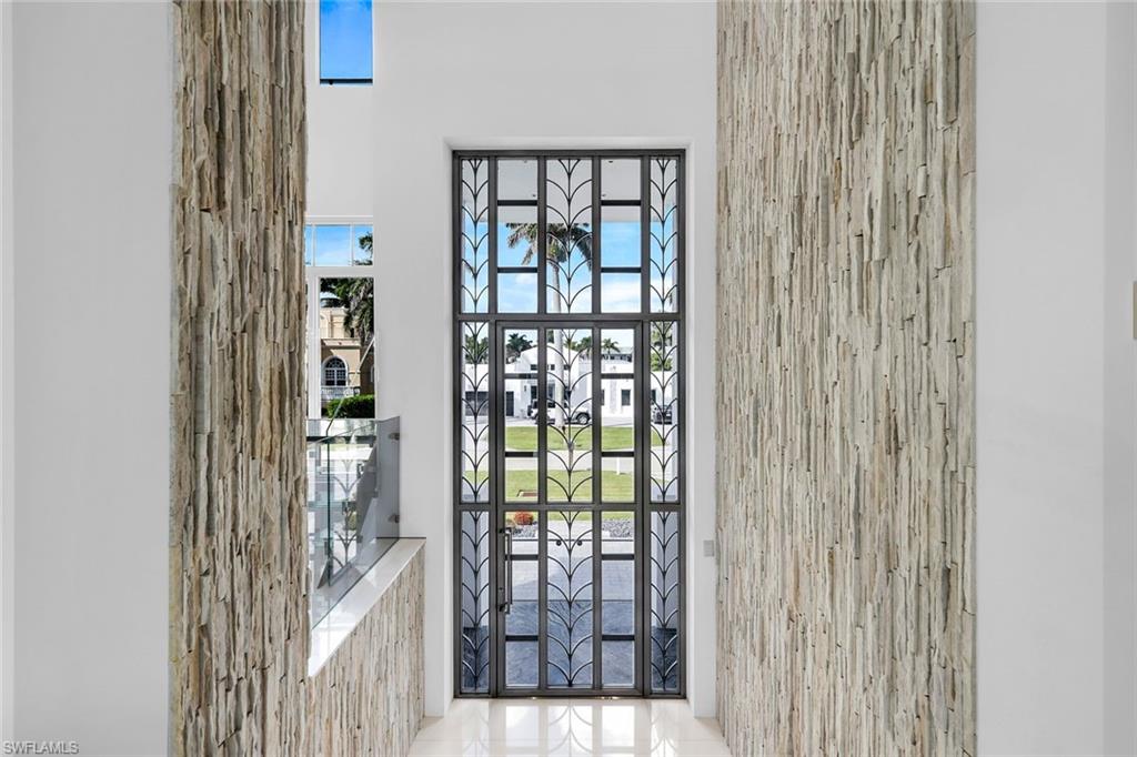 260 Channel Drive Naples, FL 34108 - Photo 3 of 48 Tiffany stainless-steel front door showcasing modern elegance and craftsmanship.
