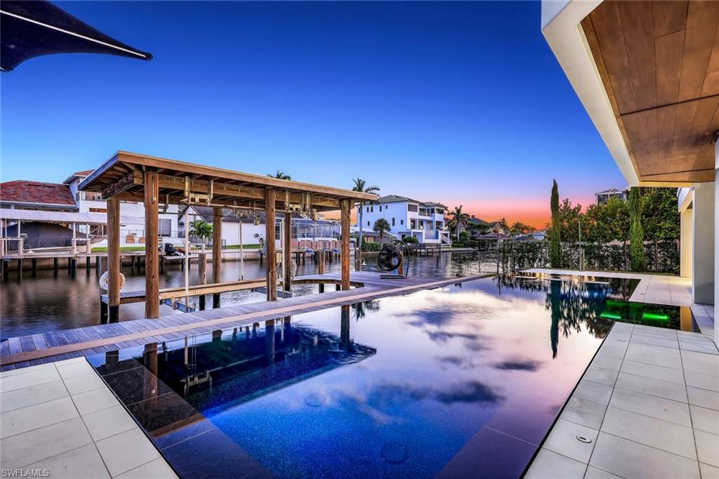 260 Channel Drive Naples, FL 34108 - Photo 41 of 48 a view of a patio with swimming pool table and chairs
