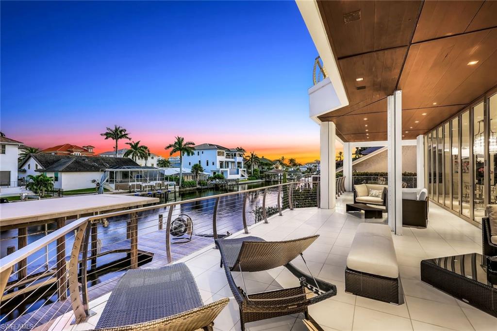 260 Channel Drive Naples, FL 34108 - Photo 42 of 48 a balcony with outdoor seating and wooden floor
