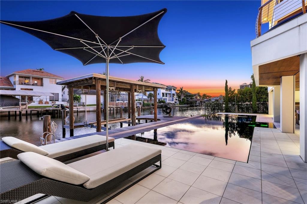 260 Channel Drive Naples, FL 34108 - Photo 43 of 48 a view of a swimming pool with outdoor seating and plants