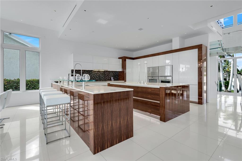 260 Channel Drive Naples, FL 34108 - Photo 8 of 48 a kitchen with stainless steel appliances kitchen island granite countertop a stove a sink and a refrigerator