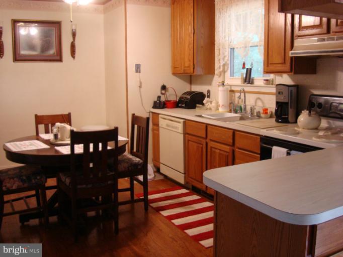 1627 Bay Ridge Road Edgewater, MD 21037 - Photo 2 of 21 a kitchen with stainless steel appliances kitchen island granite countertop a table chairs sink and cabinets