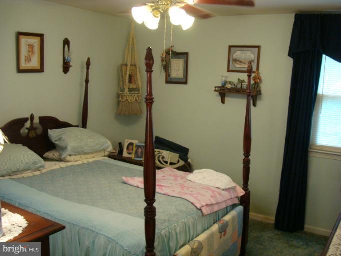 1627 Bay Ridge Road Edgewater, MD 21037 - Photo 4 of 21 a bedroom with a bed and a chandelier