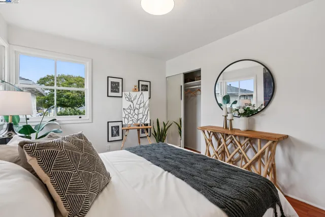 a bedroom with bed and a large windows