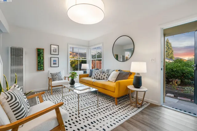 a living room with furniture a lamp and a large window