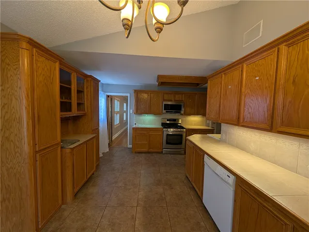 a large kitchen with a refrigerator and a stove top oven