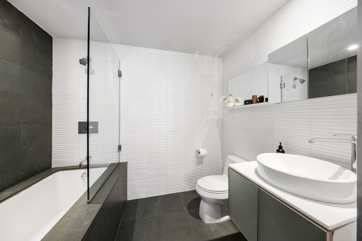 425 East 13th Street, Unit 2B Manhattan, NY 10009 - Photo 8 of 17 a bathroom with a granite countertop sink toilet and shower