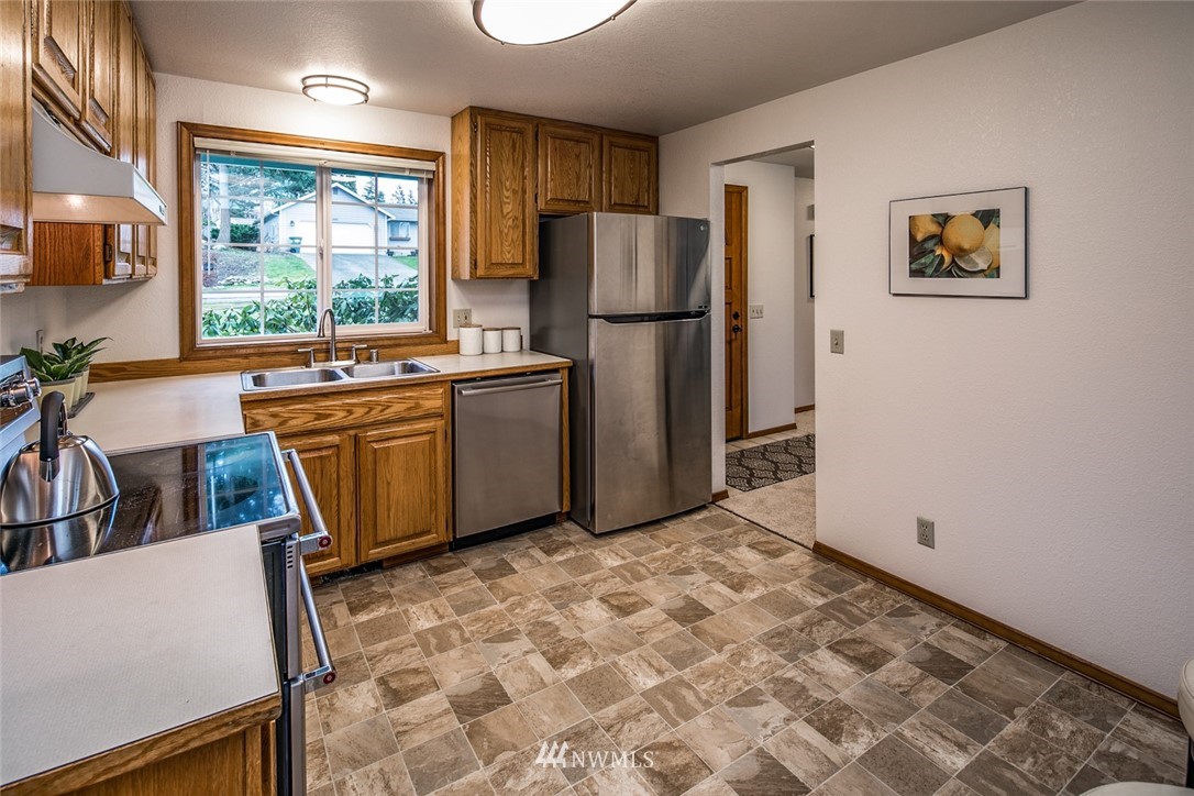 1404 Welling Road Bellingham, WA 98226 - Photo 10 of 21 a kitchen with stainless steel appliances granite countertop a refrigerator sink and wooden cabinets
