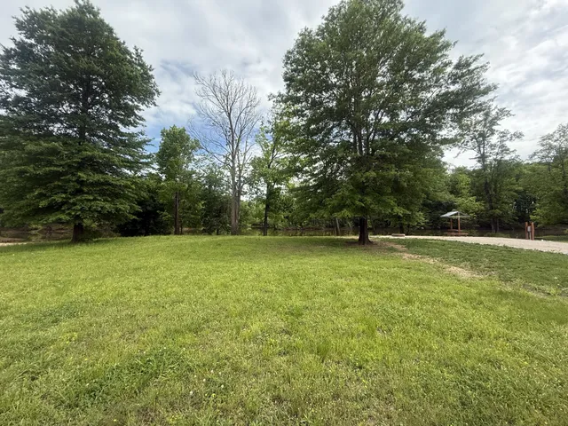 a view of a green field with wooden fence