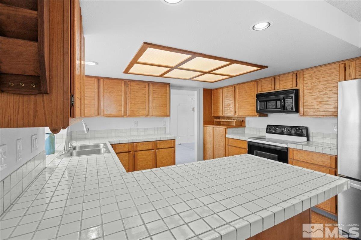 989 Ridgeview Drive Reno, NV 89511 - Photo 4 of 20 a kitchen with stainless steel appliances kitchen island granite countertop a stove top oven a sink a counter space and cabinets