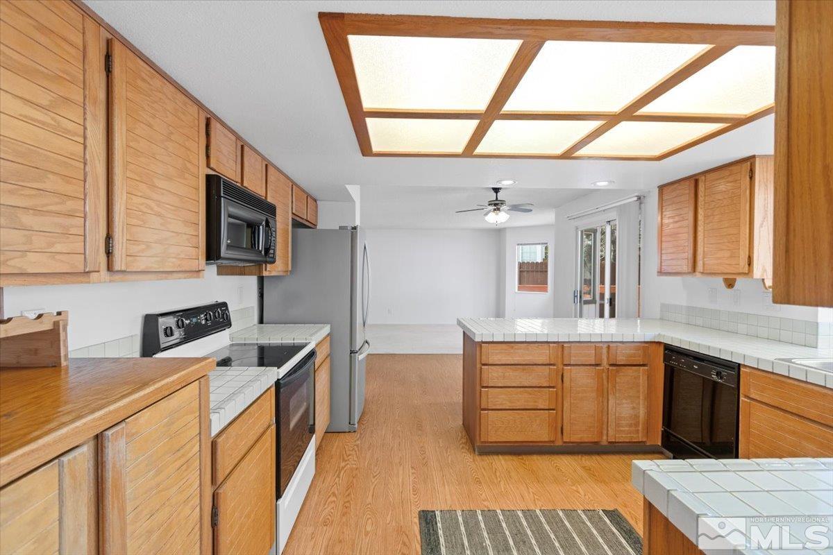 989 Ridgeview Drive Reno, NV 89511 - Photo 5 of 20 a kitchen with stainless steel appliances granite countertop a sink and a stove next to a window