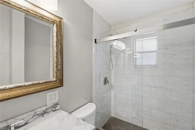 a bathroom with a granite countertop sink toilet and shower