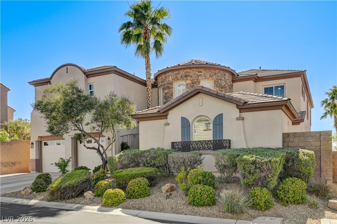2793 Rosenhearty Drive Henderson, NV 89044 - Photo 68 of 85 This residence showcases a Mediterranean-inspired façade with a prominent stone turret and well-maintained desert landscaping.