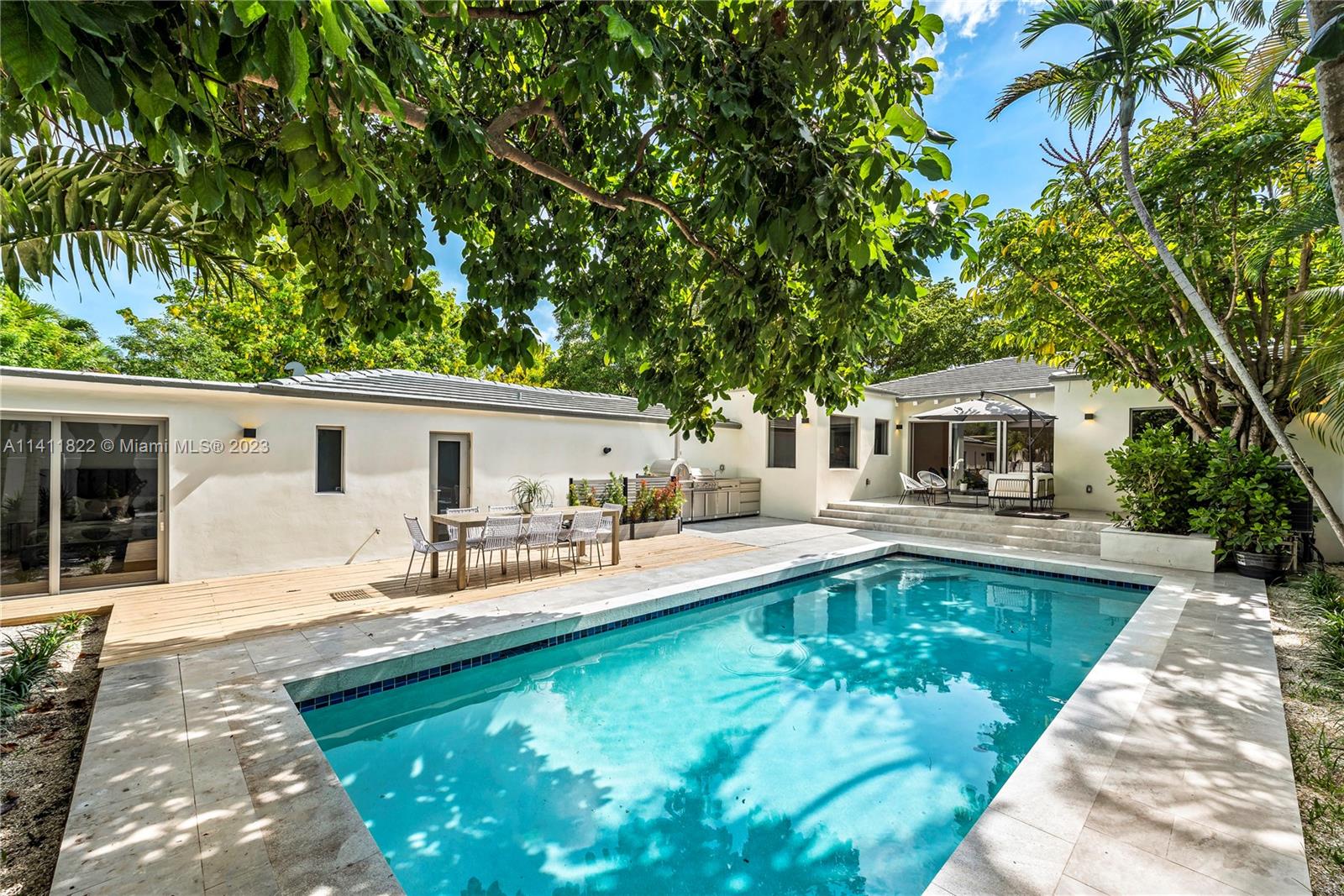 5956 Pine Tree Drive Miami Beach, FL 33140 - Photo 12 of 55 a front view of house with yard swimming pool and furniture