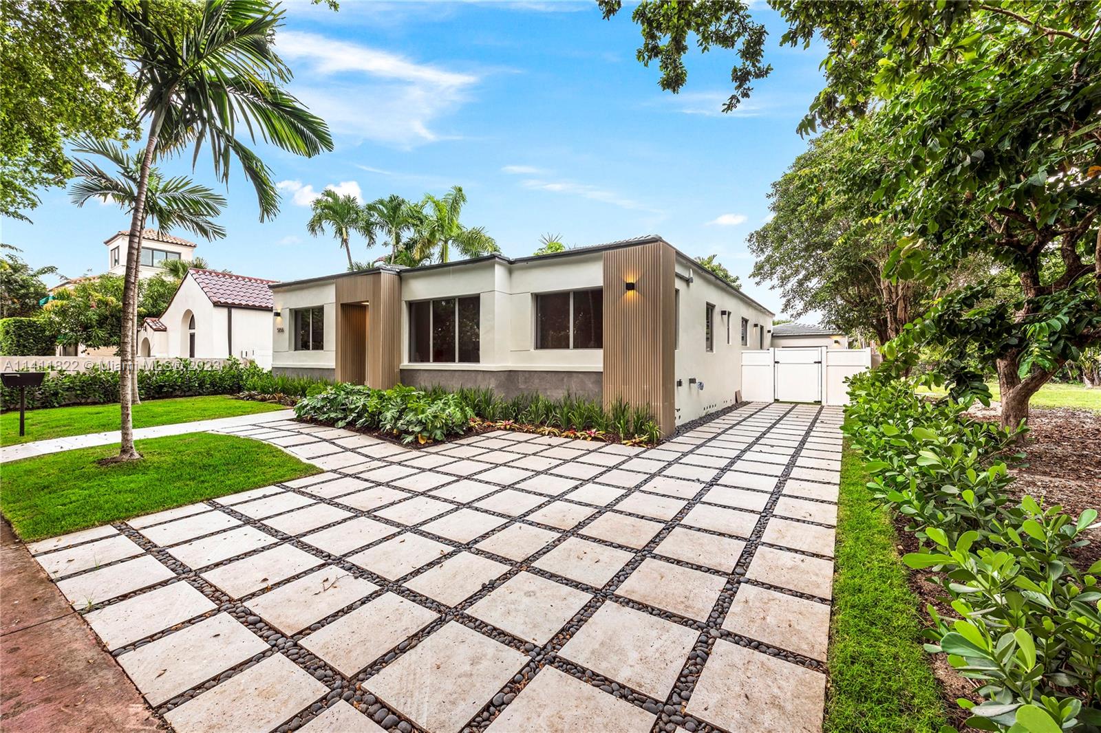 5956 Pine Tree Drive Miami Beach, FL 33140 - Photo 22 of 55 a front view of a house with a yard