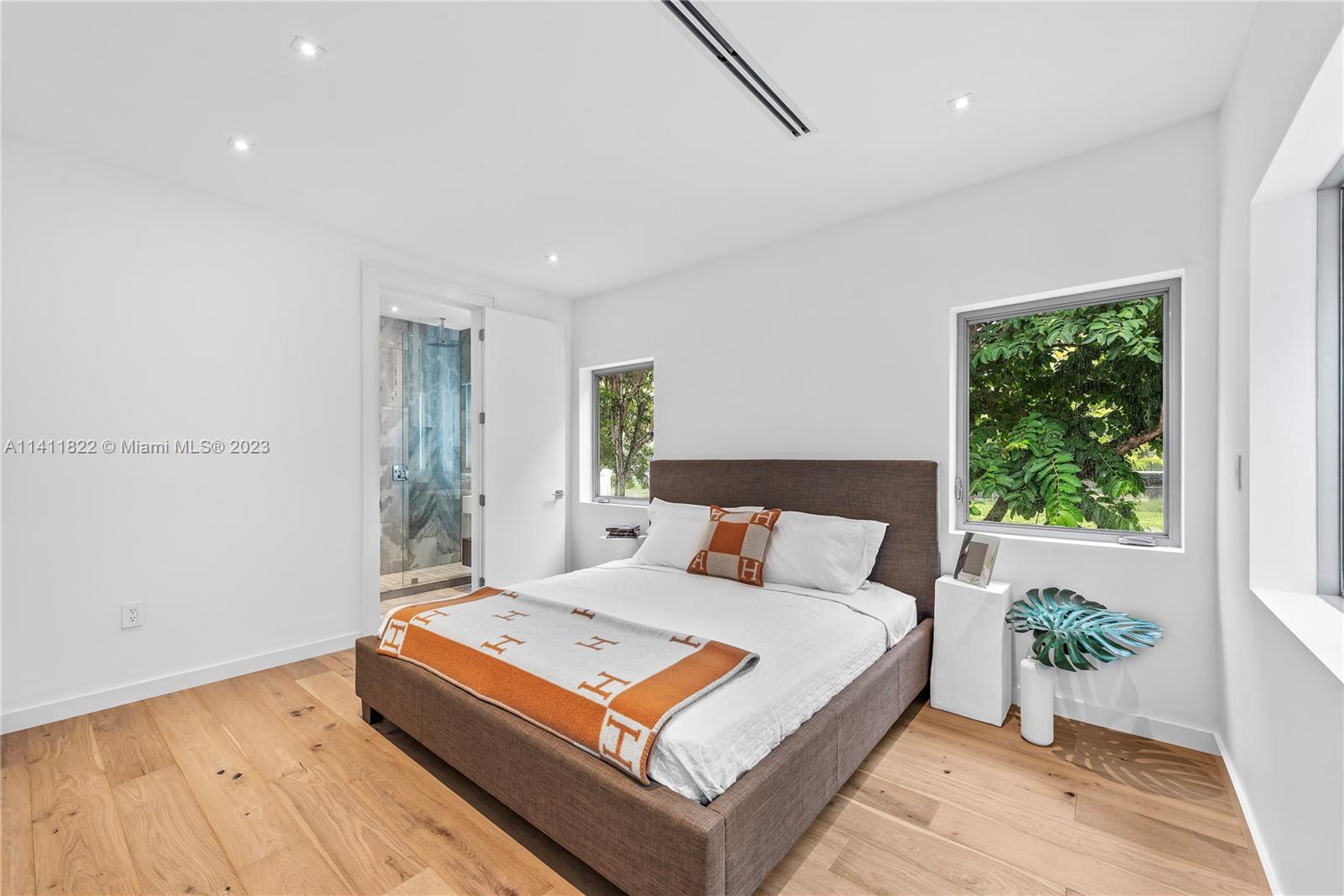 5956 Pine Tree Drive Miami Beach, FL 33140 - Photo 23 of 55 a bedroom with a large bed and a wooden floor