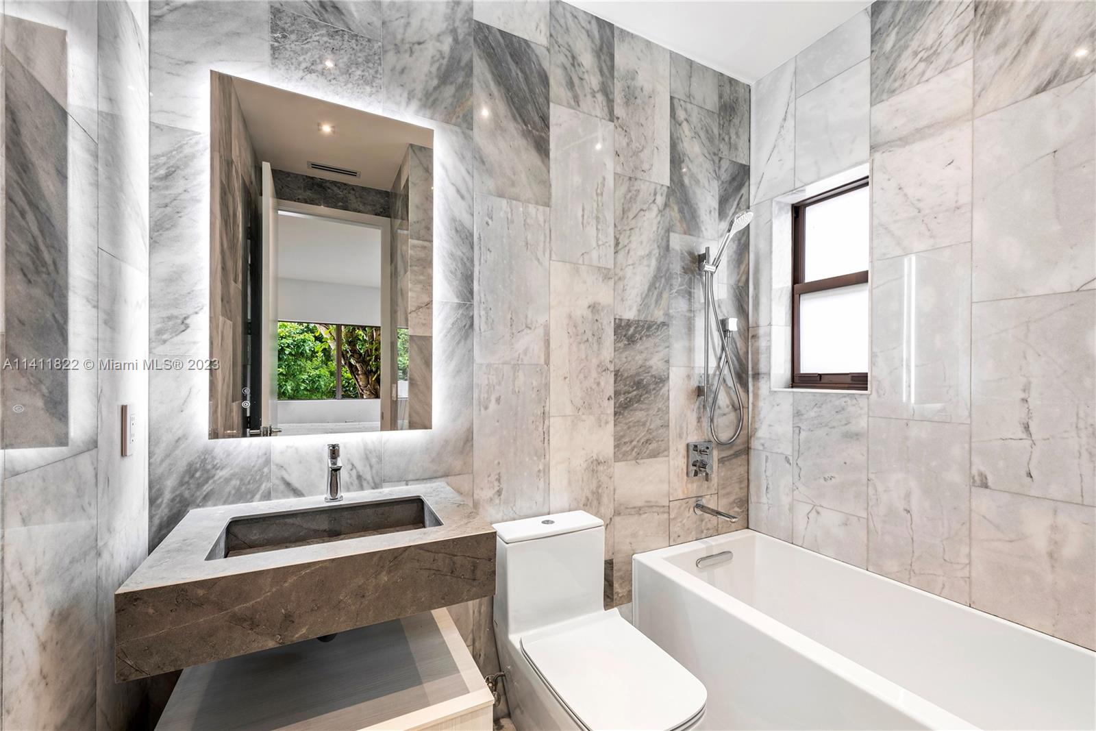 5956 Pine Tree Drive Miami Beach, FL 33140 - Photo 33 of 55 a bathroom with a tub sink toilet and a window