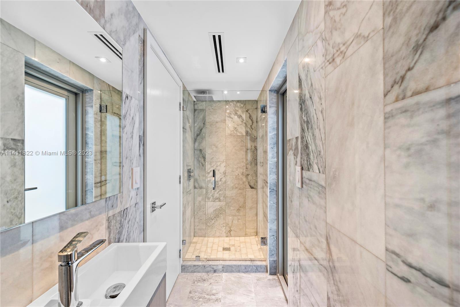 5956 Pine Tree Drive Miami Beach, FL 33140 - Photo 36 of 55 a bathroom with a tub shower and sink