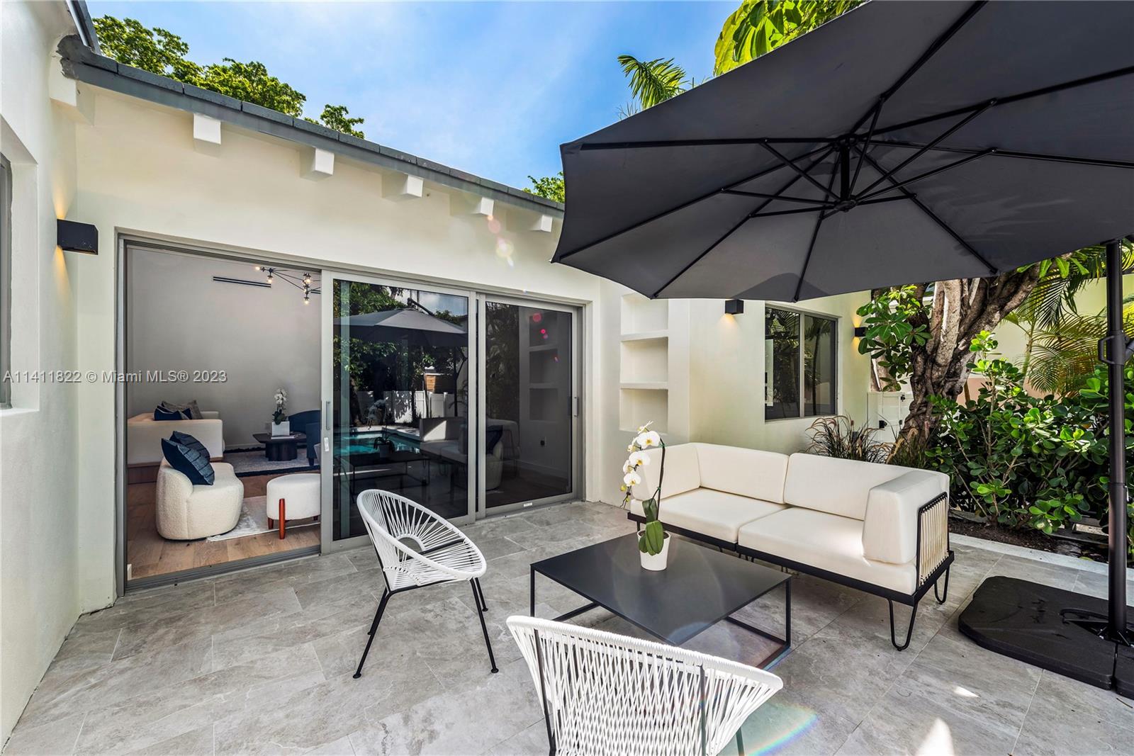 5956 Pine Tree Drive Miami Beach, FL 33140 - Photo 42 of 55 a patio with patio a table and chairs under an umbrella
