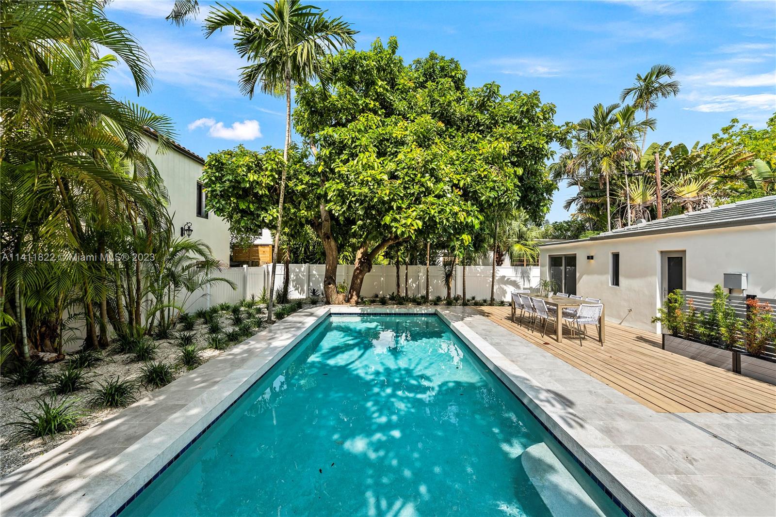 5956 Pine Tree Drive Miami Beach, FL 33140 - Photo 43 of 55 a front view of a house with garden