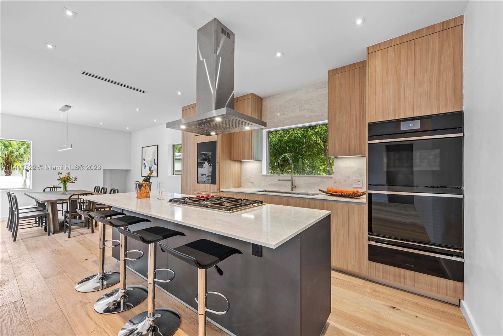 5956 Pine Tree Drive Miami Beach, FL 33140 - Photo 6 of 55 a kitchen with a table chairs sink and stove
