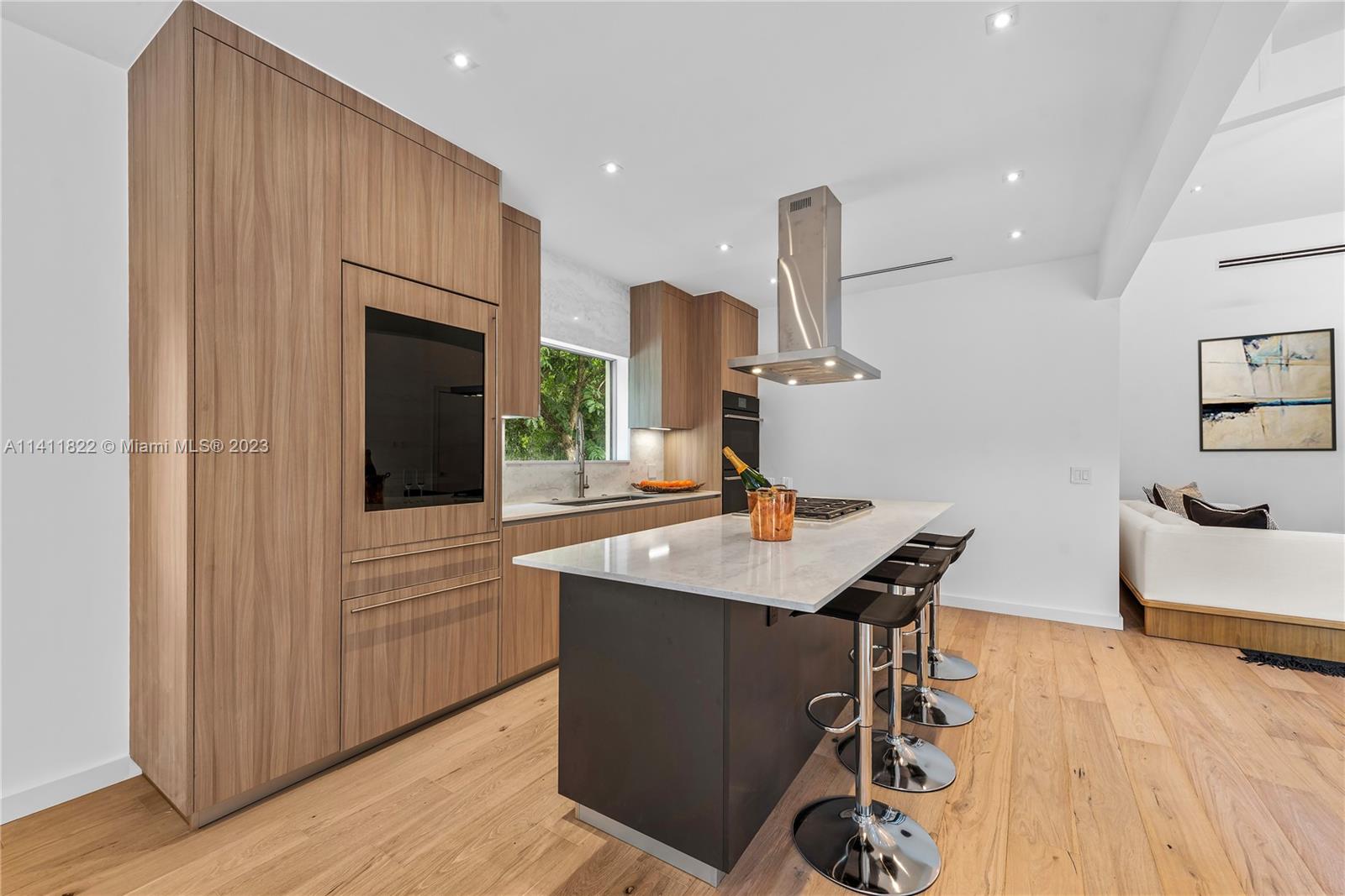 5956 Pine Tree Drive Miami Beach, FL 33140 - Photo 7 of 55 a kitchen with stainless steel appliances granite countertop a sink a stove and a wooden floor