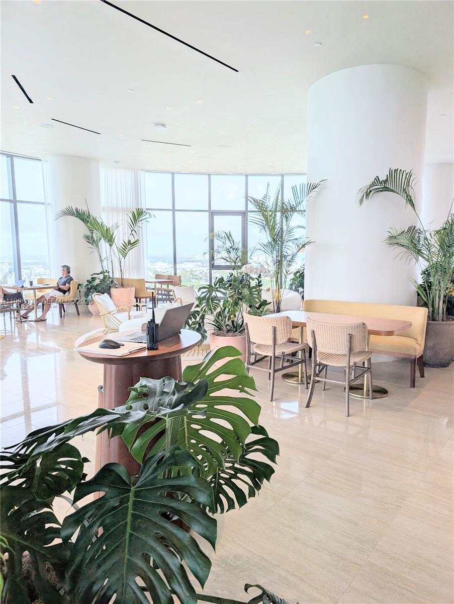 500 Alton Road, Unit 3905 Miami Beach, FL 33139 - Photo 18 of 27 a room with lots of white furniture and a potted plant