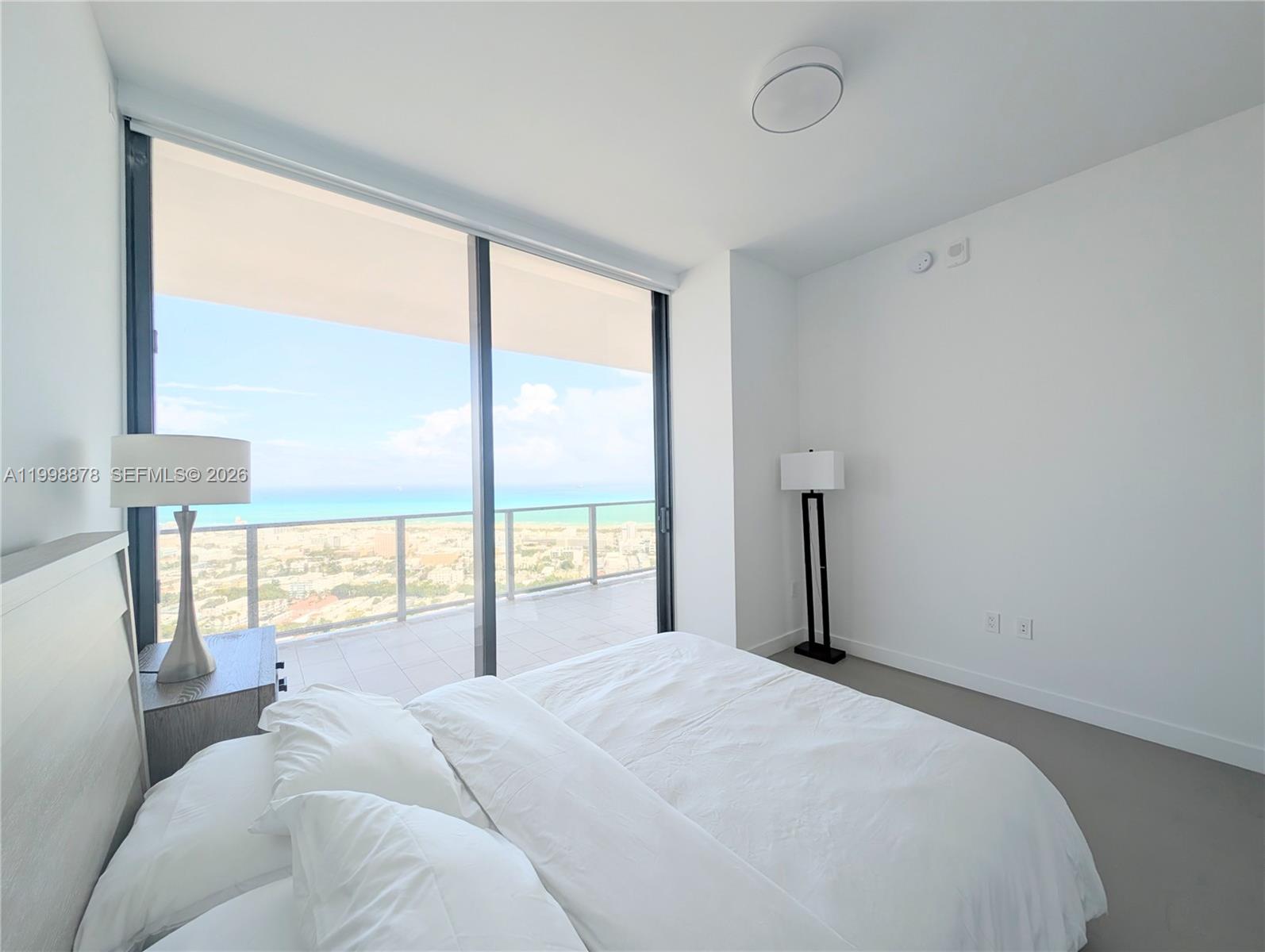 500 Alton Road, Unit 3905 Miami Beach, FL 33139 - Photo 5 of 27 a bedroom with a large bed and a large window