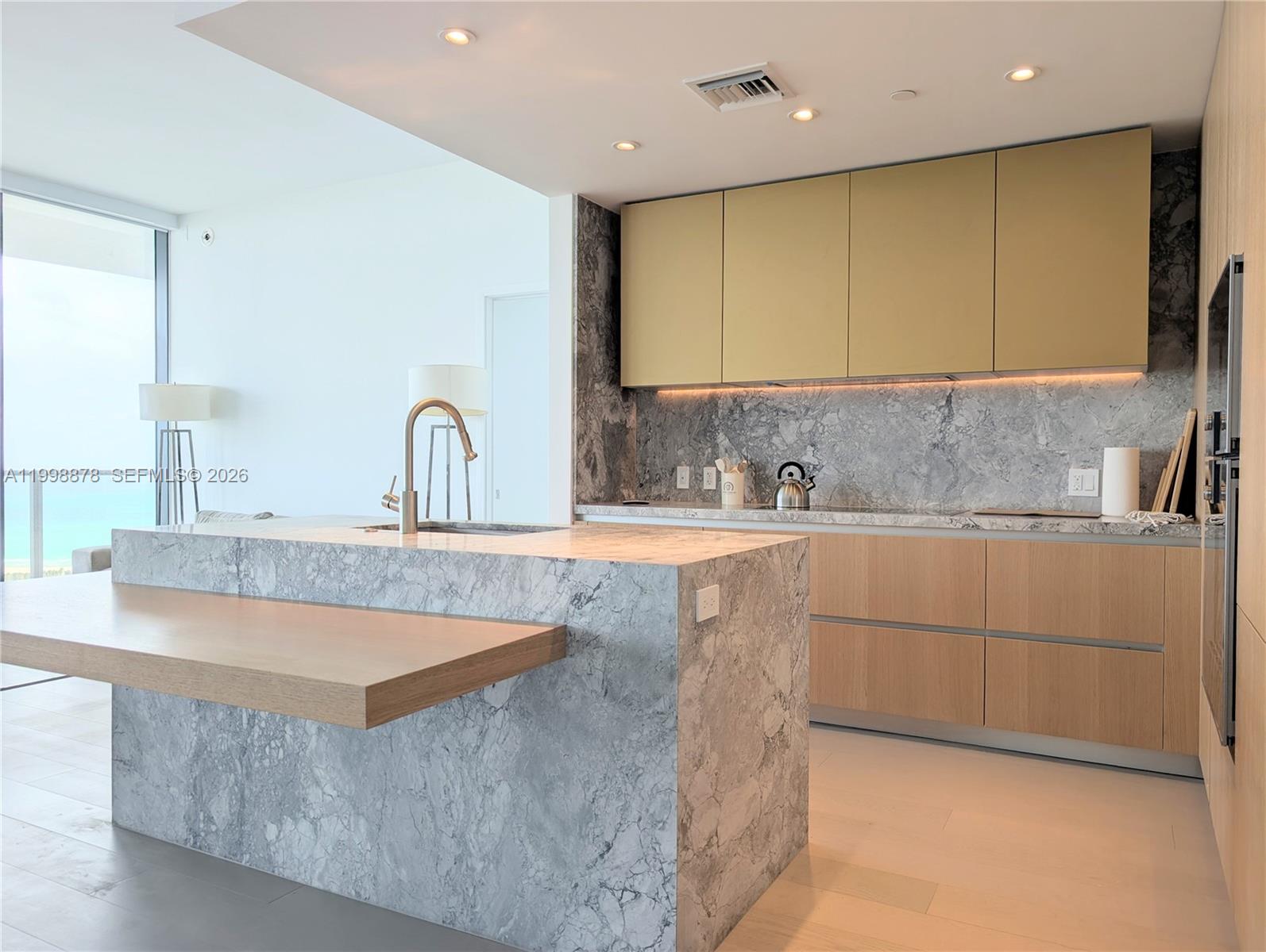 500 Alton Road, Unit 3905 Miami Beach, FL 33139 - Photo 9 of 27 a kitchen with kitchen island granite countertop a sink and a stove top oven