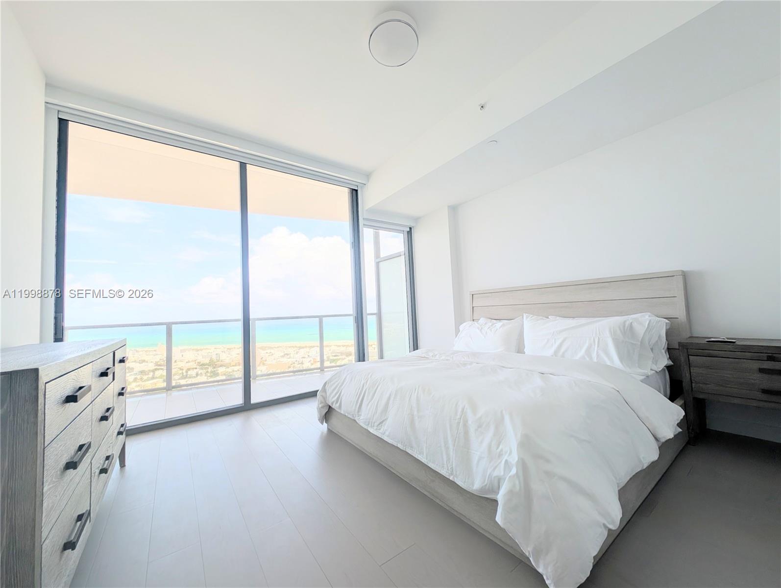 500 Alton Road, Unit 3905 Miami Beach, FL 33139 - Photo 10 of 27 a large white bed sitting in a bedroom next to a window