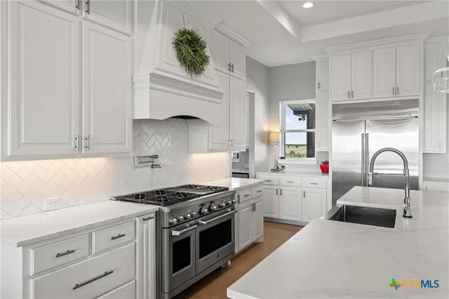 a kitchen with white cabinets and appliances