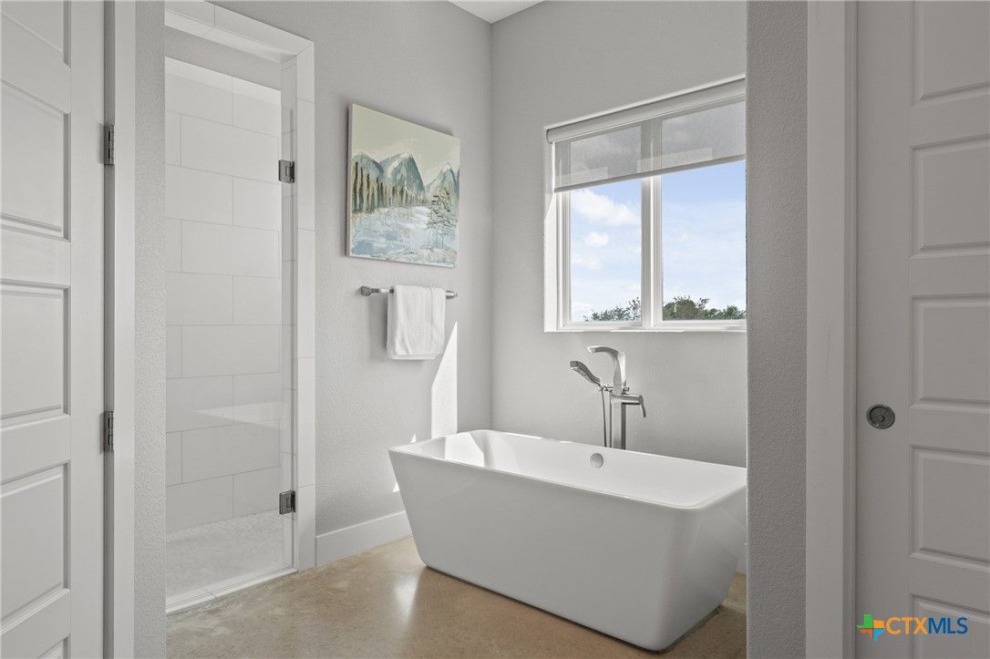 7351 Hackberry Road Holland, TX 76534 - Photo 16 of 41 a bathroom with a bathtub a shower and a window