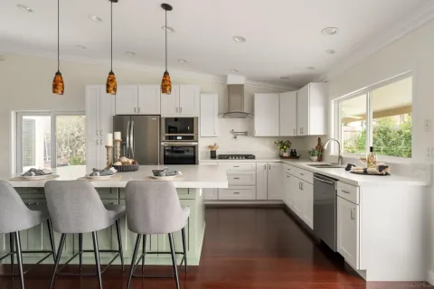 a kitchen with stainless steel appliances kitchen island a white cabinets and a couch