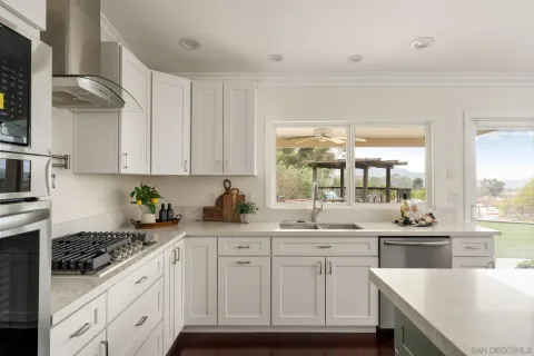 a kitchen with white cabinets and white appliances