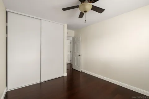 an empty room with a ceiling fan and a window