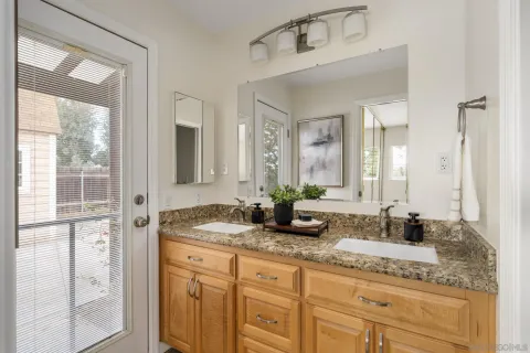 a bathroom with a granite countertop sink and a mirror