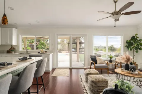 a living room with furniture and a large window with wooden floor